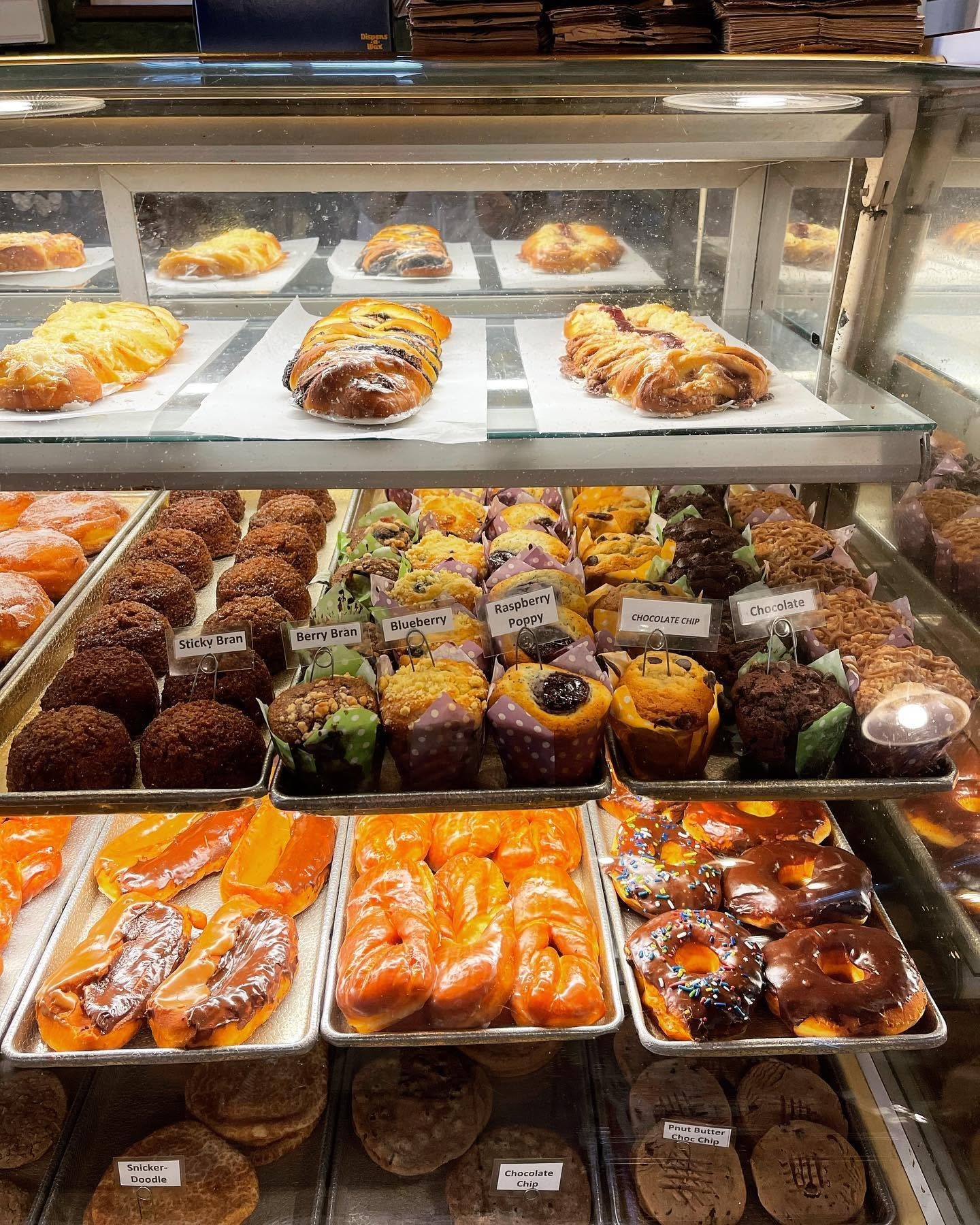 Display case with muffins, danish, and glazed donuts